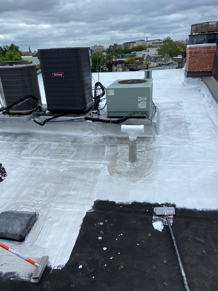 Flat rubber roof being coated